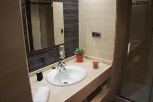 a bathroom with a white sink and a mirror at Arizonica Suites in Madrid