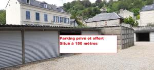 un garaje con un cartel frente a un edificio en -La Maison Balancoire - Parking privé offert - Coeur historique -La Clef de Honfleur en Honfleur