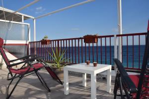 uma varanda com uma mesa e cadeiras e o oceano em Ionio Sea Apartment em Marina di Gioiosa Ionica