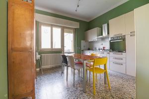 a kitchen with a table and yellow chairs in it at Appartamento Marco Polo in Viareggio