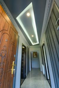 um corredor com uma porta de madeira e um tecto em KARNEL Hotel em Sanain