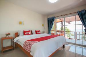 ein Schlafzimmer mit einem großen Bett und einem Balkon in der Unterkunft OYO 1085 Ma Lanta House in Ko Lanta