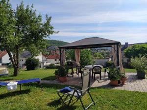um pátio com um gazebo, cadeiras e uma mesa em Haus Holzheimer em Bad Kissingen