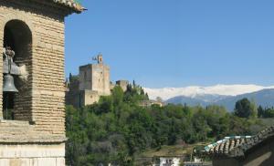 a castle on a hill with mountains in the background at San José Apartments in Granada