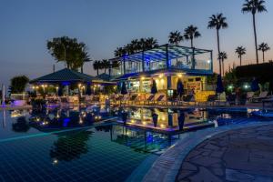 a pool at a resort with chairs and a building at Anonymous Beach Hotel (Adults 16+) in Ayia Napa