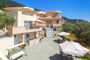 a view of a building with chairs and umbrellas at Rani Apartments in Chrysi Ammoudia