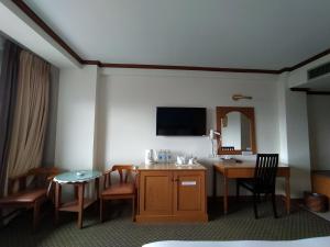 Habitación de hotel con escritorio y mesa con espejo. en Sing Golden Place Hotel, en Hat Yai