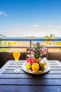 a table with a plate of fruit and a glass of orange juice at Hotel Sakouli in Bandrélé