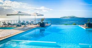 a swimming pool with a view of the ocean at Hotel Sakouli in Bandrélé