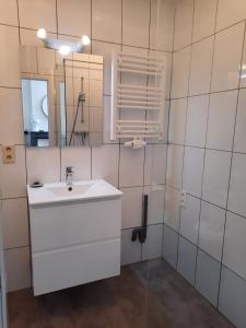 een witte badkamer met een wastafel en een spiegel bij Central and Cozy in Brussels in Brussel