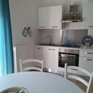 eine Küche mit einem Tisch, Stühlen und einem Backofen in der Unterkunft Casa Luna in Montesilvano