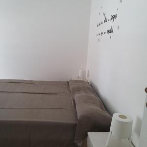 ein Bett in einem weißen Zimmer mit einem Plakat an der Wand in der Unterkunft Casa Luna in Montesilvano