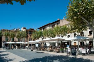 a patio with tables and chairs and umbrellas at Casa Gotmar 132 in El Port