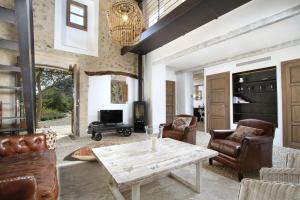 a living room with leather furniture and a table at Can Suau Dalt in El Port