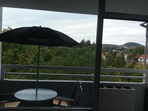 a table with an umbrella on a balcony at Home from Home in Wiebelskirchen