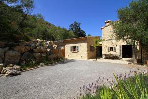 a stone house with a driveway in front of it at Can Suau Dalt in El Port