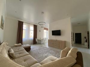 een woonkamer met een bank en een flatscreen-tv bij Modern Apartment in Lviv