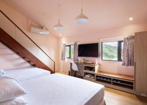 鹿谷的住宿－名竹旅社 Minzu Hotel，一间卧室配有两张床、一张桌子和一台电视。