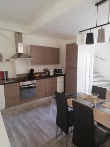 a kitchen with a table and chairs and a kitchen with brown cabinets at Ancienne caserne du château in Azille