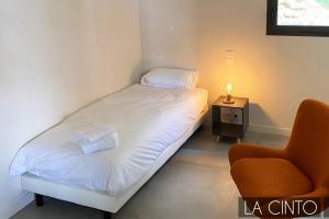 1 dormitorio pequeño con 1 cama y 1 silla en Domaine du Peyrouas, en Saint-Jeannet