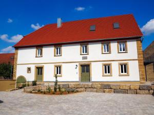 a large white house with a red roof at Ferienwohnungen Grüner Baum in Seinsheim