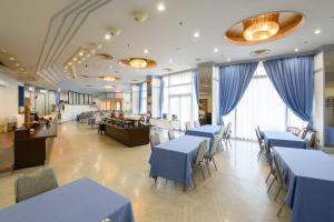 a dining room with blue tables and chairs at Hotel Tetora Resort Shizuoka Yaizu in Yaizu