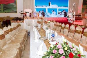 a long table with white tables and chairs with flowers at HOTEL DUY NHẤT 2 in Phú Nhơn