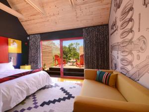 a bedroom with a bed and a couch at PitStop Lodge in Gordonʼs Bay