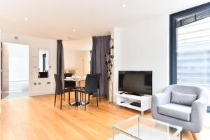 a living room with a television and a table with chairs at Central Apartments in London