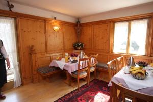 uma sala de jantar com duas mesas e duas janelas em Haus Höllental em Garmisch-Partenkirchen