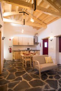 a large living room with a table and a kitchen at Casa da Orada in Outeiro