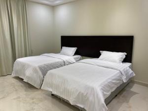 2 łóżka z białą pościelą w sypialni w obiekcie أجنحة الهيبة شمال النماص w mieście Ash Shaykh