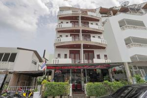 a tall white building with a sign in front of it at Tong Mee House Hua Hin in Hua Hin