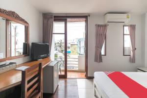 a bedroom with a bed and a desk with a television at Tong Mee House Hua Hin in Hua Hin