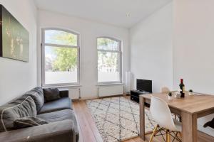 a living room with a couch and a table at Canal view apartment with private balcony in Amsterdam