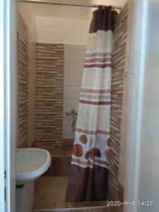 uma casa de banho com uma cortina de chuveiro e um lavatório em Restaurace ALVI em Ostrava