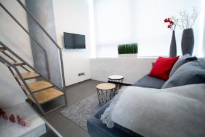 ein Wohnzimmer mit einem blauen Sofa und einem roten Kissen in der Unterkunft Vita Sana Apartments&SPA - Family loft in Zlín