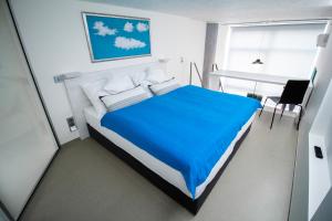 ein Schlafzimmer mit einem großen Bett mit einer blauen Decke in der Unterkunft Vita Sana Apartments&SPA - Family loft in Zlín