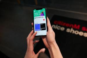 une personne tenant un téléphone portable avec les mains dans l'établissement citizenM Paris Gare de Lyon, à Paris