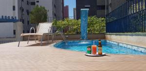 a swimming pool with a bottle of wine and two drinks at Vila Azul Praia Hotel in Fortaleza