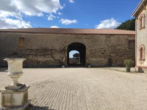 - l'entrée d'un bâtiment avec un mur en pierre dans l'établissement Château du Parc Soubise en Vendée, à Mouchamps