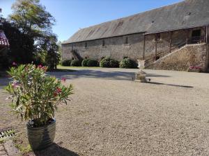- un grand bâtiment en pierre avec une cour fleurie dans l'établissement Château du Parc Soubise en Vendée, à Mouchamps