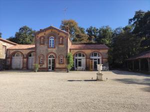 duży ceglany dom z dużym dziedzińcem w obiekcie Château du Parc Soubise en Vendée w mieście Mouchamps