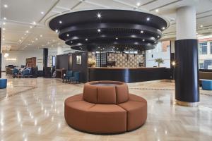 a lobby with a circular brown seat in the middle at Hotel Silken Indautxu in Bilbao