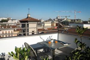 
a dining room table with a balcony overlooking a city at B&B Hotel Milano City Center Duomo in Milan
