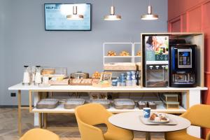 a coffee shop with a table and a coffee maker at B&B Hotel Milano City Center Duomo in Milan