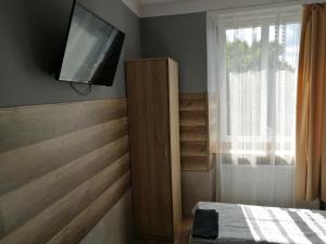 a bedroom with a bed and a tv on the wall at Pokoje Gościnne Polo in Częstochowa