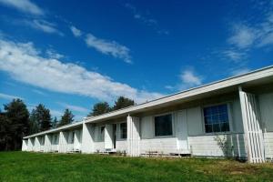 un edificio blanco en un campo con un cielo azul en Lokkankoti A, en Lokka