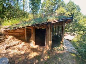 Cabaña con techo de hierba en una terraza de madera en Hobbit house, en Ripanj