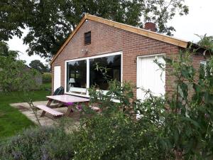 una casa con una mesa de picnic frente a una ventana en Diekinkshof en Laren